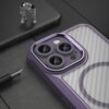 Fioletowe etui na telefon z trzema dużymi otworami na aparaty, leży na ciemnej powierzchni obok metalicznej figurki i pióra wiecznego. Etui ma przezroczysty tył z widocznym wzorem przypominającym włókno węglowe.
