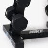 Czarny stojak na hantle z widocznymi hantlami, na podstawie znajduje się logo "NIKE". Konstrukcja jest metalowa, z widocznymi śrubami mocującymi.