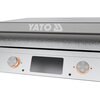 Grill elektryczny na stojaku z dwoma kółkami, wykonany z metalu, z dwoma pokrętłami na panelu przednim. Na górnej części grilla oraz na stojaku widoczne jest logo "YATO".