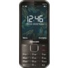 Telefon komórkowy z wyświetlaczem pokazującym godzinę 12:46 oraz datę 15-02-2022 Czw, z tłem w liście i napisami "Menu" oraz "Kontakty". Na obudowie widoczne jest logo "maxcom", a poniżej znajduje się klawiatura numeryczna.
