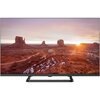 Telewizor KIVI 32H710QB 32" LED Google TV wyświetla krajobraz pustynny z formacjami skalnymi oświetlonymi zachodzącym słońcem. Na dolnej ramce telewizora widnieje logo "KIVI".