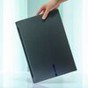Na zdjęciu widoczny jest zamknięty laptop w kolorze ciemnoszarym, trzymany przez rękę. Na obudowie znajduje się logo "GIGABYTE".