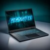 Na zdjęciu znajduje się otwarty laptop z podświetlaną klawiaturą, na którego ekranie widnieje napis "GIGABYTE" w niebieskim kolorze. Laptop stoi na gładkiej powierzchni, a tło jest rozmyte i utrzymane w ciemnych odcieniach.