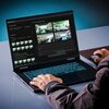 Laptop z podświetlaną klawiaturą wyświetla na ekranie interfejs oprogramowania do generowania obrazów, z widocznymi miniaturami czterech wygenerowanych wnętrz. Na ekranie znajduje się tekst: "GIGABYTE Creator", "Content Type", "Inference", "Picture genera
