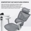 Szary fotel biurowy z regulowanym oparciem i zagłówkiem, obok którego znajduje się fragment biurka z czarnymi słuchawkami. Na zdjęciu widoczny jest tekst: "KOMFORTOWY KĄT NACHYLENIA OPARCIA Dzięki mechanizmowi swobodnego pochylania, oparcie fotela X-Air u