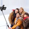 Czarny uchwyt selfie o nowoczesnym, minimalistycznym designie, złożony w kompaktową formę. Widoczne są elementy konstrukcyjne, takie jak przeguby i okrągły przycisk.