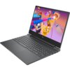 Laptop z otwartym ekranem wyświetlającym kolorową grafikę z gry, z widoczną klawiaturą i touchpadem. Na obudowie znajduje się logo w kształcie litery "V".