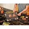 Na zdjęciu znajduje się grill elektryczny z otwartą pokrywą, na którym grillowane są kawałki mięsa, plastry cukinii i szparagi. Na panelu sterowania grilla widoczne są cyfry: "240°C", "60", "200°C".