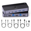 Na zdjęciu widoczny jest przełącznik KVM UGREEN CM664 z różnymi portami, w tym HDMI i USB, oraz zestaw kabli o różnych końcówkach. Na urządzeniu znajduje się logo "UGREEN" oraz oznaczenie "4K 60Hz".