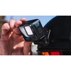 Na zdjęciu widać kamerę sportową zamontowaną na rowerze, z widocznym logo "GoPro" na obudowie. Kamera jest ustawiona w pobliżu łańcucha i zębatki rowerowej, a ręka trzymająca uchwyt montażowy jest widoczna w tle.