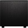 Czarny subwoofer o prostokątnym kształcie z widoczną teksturą drewna na powierzchni. Produkt stoi na czterech niewielkich nóżkach.