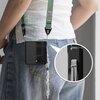 Na zdjęciu widoczne jest czarne etui na telefon Samsung Galaxy Z Flip 7, zawieszone na zielonym pasku, z detalem pokazującym sposób mocowania sznurka. Etui jest ozdobione przezroczystym brelokiem z koralikami.