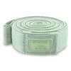 Na zdjęciu widoczna jest zwinięta, jasnozielona guma do ćwiczeń z teksturą, z naszywką zawierającą napis "SPOKEY 7-12 kg MEDIUM". Produkt ma prostokątną naszywkę w tym samym kolorze co guma.