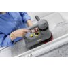 Osoba w niebieskiej koszuli obsługuje szorowarkę do czyszczenia schodów marki KARCHER, model BD 17/5 C Ep 1.737-107.0, umieszczoną na granitowej powierzchni. Na urządzeniu widoczne jest logo "KARCHER" oraz pokrętło regulacyjne.