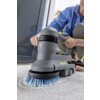 Na zdjęciu widoczna jest szorowarka do czyszczenia schodów z niebieską szczotką, używana na jasnym dywanie. Na urządzeniu znajduje się logo "KARCHER".