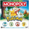 Okładka gry planszowej Monopoly Pokémon z kolorową grafiką przedstawiającą postacie z Pokémonów oraz logo Monopoly na górze. Na dole widnieje napis: "Podróżuj po planszy i łap dzikie Pokémony!" oraz logo Hasbro Gaming.
