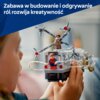 Na zdjęciu widoczny jest zestaw klocków LEGO przedstawiający scenę z pociągiem, z figurkami postaci oraz mechanizmami przypominającymi macki. W górnej części zdjęcia znajduje się tekst: "Zabawa w budowanie i odgrywanie ról rozwija kreatywność".