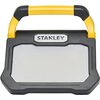 Czarny reflektor z żółtym uchwytem, na którym widnieje logo "STANLEY". Przednia część reflektora jest płaska i jasna.