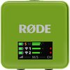 Zielone urządzenie z logo "RØDE" na górze oraz wyświetlaczem poniżej, na którym widoczne są ikony baterii, symbol "S", ikony sygnału Wi-Fi oznaczone numerami "1" i "2", oraz wskaźniki poziomu zasilania i sygnału. Na wyświetlaczu znajdują się także oznacze