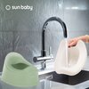Na zdjęciu widoczny jest biało-zielony nocnik oraz ręka trzymająca jego część pod strumieniem wody z kranu. W tle znajduje się szara ściana z logo "sun baby".