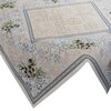 Obrus o wymiarach 100 x 100 cm z wzorem w oliwki i niebieskie ornamenty na beżowym tle, z centralnym kwadratowym panelem ozdobionym symetrycznymi wzorami. Obrzeża są ozdobione delikatnym, niebieskim wzorem przypominającym koronkę.