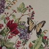 Na zdjęciu widoczny jest fragment materiału z wzorem przedstawiającym kolorowe kwiaty, liście oraz motyla. Tło jest jasne, a wzór zawiera odcienie czerwieni, fioletu, zieleni i żółci.