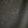 Grafitowa tkanina z widocznymi kroplami wody na powierzchni, co sugeruje jej wodoodporność. Struktura materiału jest wyraźnie widoczna, z drobnym, regularnym splotem.