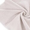 Jasnoróżowy ręcznik o gładkiej fakturze, ułożony w spiralny wzór, ukazujący miękką i puszystą powierzchnię materiału. Produkt ma wymiary 50 x 90 cm.