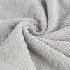 Na zdjęciu widoczny jest srebrny ręcznik o wymiarach 30 x 50 cm, złożony w sposób ukazujący jego teksturę i miękkość. Materiał ma delikatny wzór i puszystą strukturę.