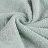 Miętowy ręcznik o fakturze frotte, ułożony w sposób tworzący miękkie fałdy. Produkt to "Ręcznik Loren (05) 50 x 90 cm Miętowy".