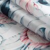 Zbliżenie na materiał z wzorem kwiatowym w odcieniach różu, niebieskiego i zielonego, z widocznymi detalami liści i płatków. Tkanina jest złożona, ukazując różnorodność kolorów i wzorów.