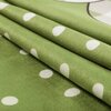 Zielony materiał z białymi kropkami, ułożony w fałdy. Tkanina ma gładką teksturę i jednolity wzór.