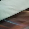 Zdjęcie przedstawia fragment pościeli w kolorze miętowo-stalowym, z widocznym gładkim materiałem oraz wzorem w odcieniach brązu i niebieskiego. Brak widocznych napisów lub logo.