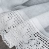 Biała firana z delikatnym, ażurowym wzorem na brzegu, wykonana z lekkiego materiału o drobnej siateczkowej strukturze. Produkt to "Firana gotowa EUROFIRANY Lari 150 x 30 cm Biały".