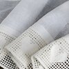 Zdjęcie przedstawia kremową firanę z delikatnym, siateczkowym wzorem oraz ozdobnym brzegiem z motywem serc. Materiał ma subtelną teksturę, która dodaje elegancji i lekkości.