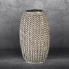 Srebrny wazon o wymiarach 16 x 12 x 27 cm z fakturą przypominającą plecionkę, umieszczony na szarym tle. Wazon ma owalny kształt i błyszczącą powierzchnię.