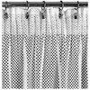 Biała firana o wymiarach 140 x 270 cm z wzorem w czarne kropki, zawieszona na metalowym karniszu za pomocą klipsów. Materiał jest lekko marszczony, co tworzy efekt falowania.