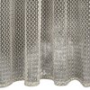 Beżowa firana o wymiarach 140 x 250 cm z delikatnym, ażurowym wzorem geometrycznym, tworzącym regularne, symetryczne motywy. Materiał jest lekko pofalowany na dole, co dodaje mu elegancji.