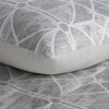 Szara pościel z geometrycznym wzorem w białe linie i okręgi, widoczna na poduszce i kołdrze. Materiał ma teksturę przypominającą pociągnięcia pędzla.