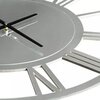 Zbliżenie na stalowy zegar ścienny z czarnymi wskazówkami i rzymskimi cyframi na obwodzie. Tarcza zegara jest okrągła i ma metaliczne wykończenie.
