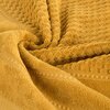 Zdjęcie przedstawia miodowy ręcznik o teksturze z wyraźnym wzorem geometrycznym. Materiał wygląda na miękki i puszysty, z widocznymi detalami splotu.