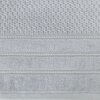 Srebrny ręcznik o wymiarach 30 x 50 cm z widocznym wzorem w kratkę na górnej części oraz trzema poziomymi pasami z delikatnym zdobieniem poniżej. Materiał ma teksturę frotte, co nadaje mu miękkości i puszystości.