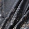 Zbliżenie na materiał zasłony w kolorze czarnym z nieregularnym, jasnym wzorem przypominającym przetarcia. Tkanina ma aksamitną fakturę i jest lekko pofałdowana.