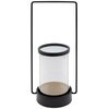 Czarny świecznik o wymiarach 15 x 12 x 32 cm z przezroczystym cylindrycznym szkłem, osadzony na okrągłej podstawie z metalowym uchwytem w kształcie prostokąta. Produkt marki EUROFIRANY.