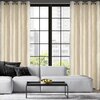Na zdjęciu widoczny jest salon z dużym oknem, przy którym wiszą kremowe zasłony EUROFIRANY Emilia 140 x 250 cm. Przed oknem stoi jasna sofa z ciemnymi poduszkami oraz niski stolik z miską pełną zielonych jabłek.
