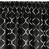 Czarno-srebrna zasłona z wzorem w geometryczne, faliste linie tworzące symetryczne kształty. Materiał ma lekko połyskującą powierzchnię, co dodaje elegancji.
