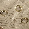 Ciemnobeżowo-szampańska zasłona z geometrycznym wzorem w złotym kolorze, posiadająca metalowe przelotki w złotym odcieniu. Materiał ma delikatny połysk, a wzór tworzy regularne, kanciaste kształty.