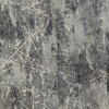 Zdjęcie przedstawia fragment materiału o abstrakcyjnym wzorze w odcieniach srebra i beżu, z nieregularnymi liniami i teksturą przypominającą pęknięcia. Wzór jest dynamiczny, z różnymi odcieniami szarości i beżu, tworzącymi efekt głębi.