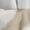 Zdjęcie przedstawia fragment zasłony w kolorach biało-beżowych z wyraźną teksturą materiału. Na krawędzi zasłony widoczna jest ozdobna frędzla w beżowym odcieniu.