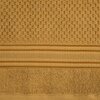 Zdjęcie przedstawia miodowy ręcznik o wymiarach 50 x 90 cm z wyraźną teksturą i wzorem w kratkę. Na powierzchni ręcznika widoczne są również poziome pasy z delikatnym wzorem.
